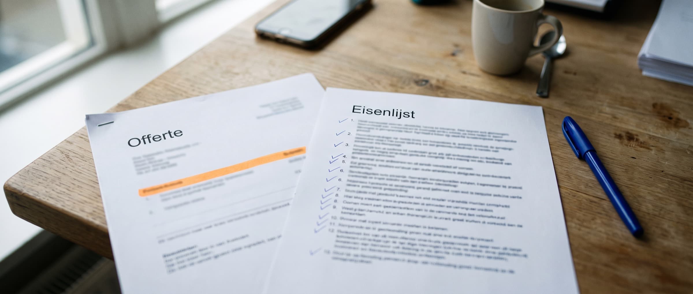 Uitgeprinte eisenlijst met aantekeningen in pen naast de offerte van een softwareleverancier op een bureau