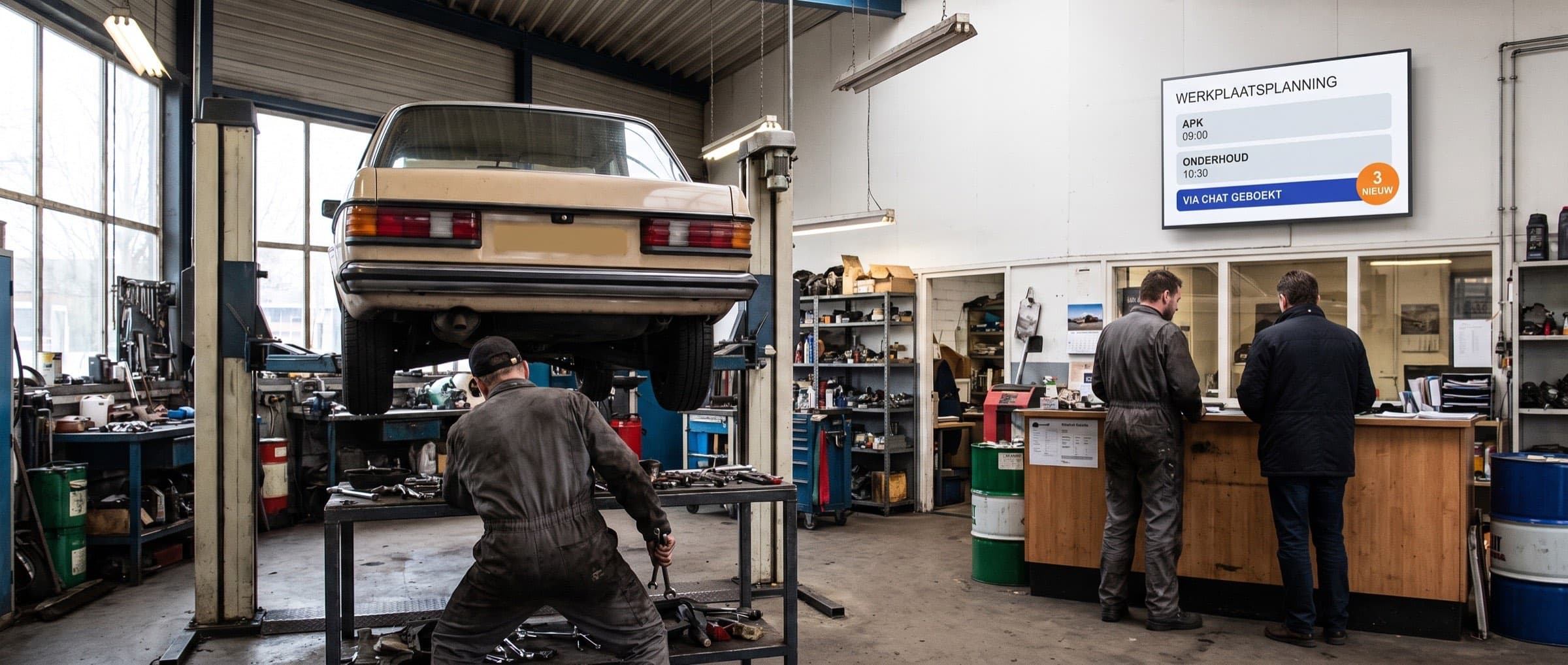 Monteur werkt aan een auto op de brug, aan de balie helpt een collega een klant en op een scherm aan de muur staat de dagplanning
