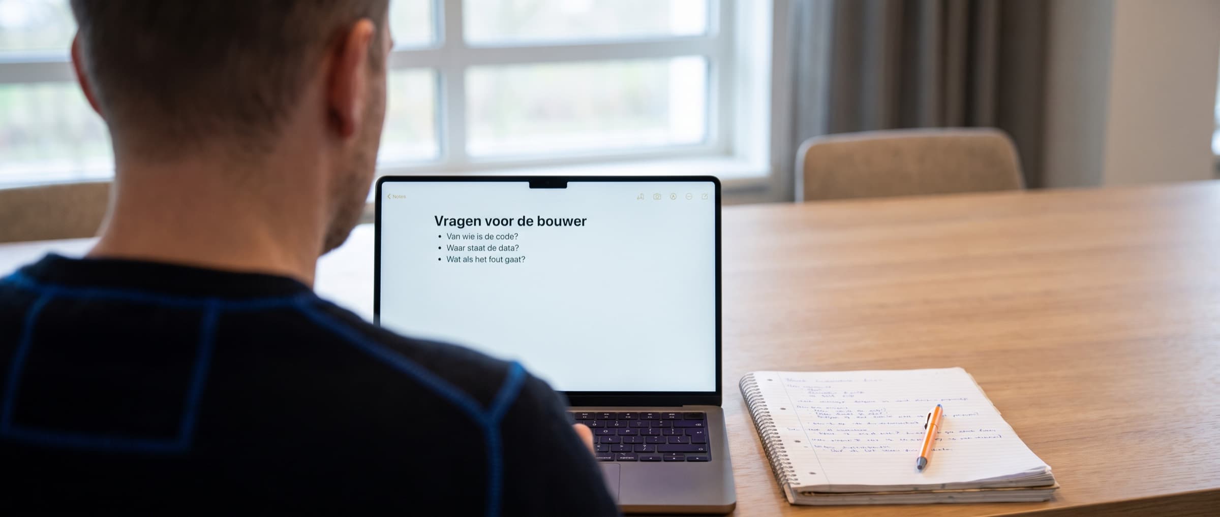 Ondernemer schrijft vragen op voor een gesprek met een AI-bouwer